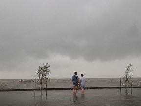 People watch waves break against a floodwall in a park along the shore of Lake Pontchartrain after the area flooded in the wake of Hurricane Barry on July 13, 2019 in Mandeville, Louisiana.  (Olson/Getty Images)