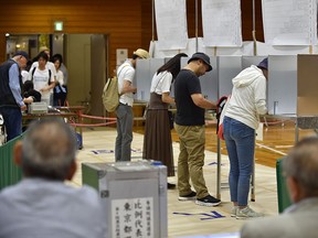 Voters fill out their ballots to vote in Parliament's upper house election at a polling station in Tokyo on July 21, 2019.