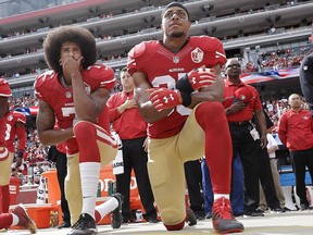 In this Oct. 2, 2016 file photo, from left, San Francisco 49ers quarterback Colin Kaepernick and safety Eric Reid kneel during the national anthem before a game against the Dallas Cowboys in Santa Clara, Calif. (File photo)