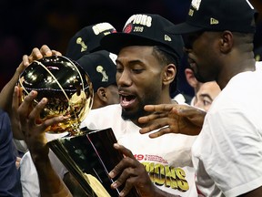 Kawhi Leonard of the Toronto Raptors celebrates with the Larry O'Brien Trophy after his team defeated the Golden State Warriors at ORACLE Arena on June 13, 2019 in Oakland.