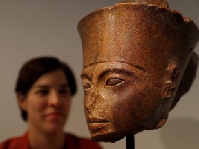 Laetitia Delaloye, head of antiquities of Christie's, poses for a photograph with an Egyptian brown quartzite head prior to its' sale at Christie's auction house in London, July 4, 2019. (REUTERS/Peter Nicholls)