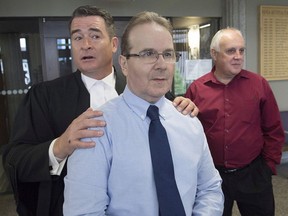 Glen Assoun, the Nova Scotia man who spent almost 17 years in prison for a crime he didn't commit, his lawyer Sean MacDonald and Ron Dalton, right, from the advocacy group Innocence Canada, stand outside Supreme Court in Halifax on Friday, July 12, 2019. A judge had ordered the full release of a federal Justice Department report that led to the exoneration of Assoun, wrongfully convicted of murder.