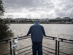 A man pays his respects from a pier on the Loire River, on July 30 2019, in Nantes, where the body of Steve Maia Canico, 24, who disappeared over a month ago during a police raid on a music festival, had been found in the Loire river the day before. (LOIC VENANCE/AFP/Getty Images)