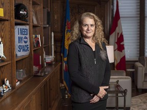 Gov. Gen. Julie Payette stands next to a shelf featuring memorabilia from her career as an astronaut, in her office at Rideau Hall in Ottawa on Dece. 11, 2018.