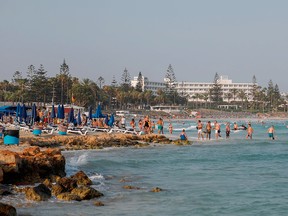Tourists swim in the Cypriot resort town of Ayia Napa on July 18, 2019.