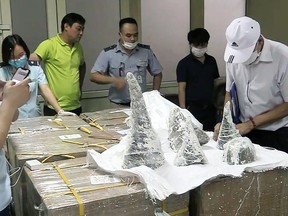 This picture from the Vietnam News Agency taken on July 25, 2019 and released on July 27, 2019 shows customs officials at Noi Bai International Airport removing smuggled rhino horn pieces from packaging in Hanoi.