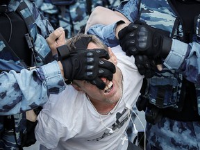 Law enforcement officers detain a participant of a rally calling for opposition candidates to be registered for elections to Moscow City Duma, the capital's regional parliament, in Moscow, Russia July 27, 2019.