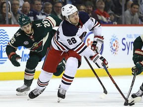 Minnesota Wild centre Ryan Donato reaches fof the puck during a game against the Jets in Winnipeg on Tues., Feb. 26, 2019. (Kevin King/Postmedia Network)