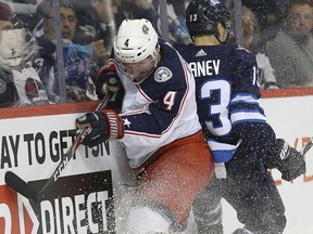 Winnipeg Jets forward Brandon Tanev (right) and Columbus Blue Jackets defenceman Scott Harrington hit the end boards in Winnipeg on Thurs., Jan. 30, 2019. (Kevin King/Winnipeg Sun)