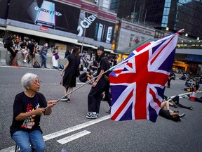 Alexandra Wong, 63, holds up a Union Flag during a demonstration demanding Hong Kong's leaders step down and withdraw an extradition bill, in Hong Kong, China, June 17, 2019. (REUTERS/Athit Perawongmetha)