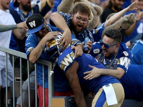 Winnipeg Blue Bombers receiver Darvin Adams is mobbed by fans while celebrating a touchdown from Nic Demski during CFL action against the Edmonton Eskimos in Winnipeg on Thurs., June 27, 2019.