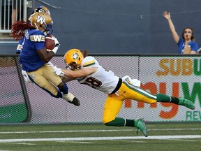 Winnipeg Blue Bombers receiver Lucky Whitehead dives into the end zone ahead of Edmonton Eskimos linebacker Kevin Francis during CFL action in Winnipeg on Thurs., June 27, 2019.