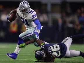 Ezekiel Elliott of the Dallas Cowboys breaks a tackle attempt by Shaquill Griffin of the Seattle Seahawks in the fourth quarter during the Wild Card Round at AT&T Stadium on January 05, 2019 in Arlington, Texas.