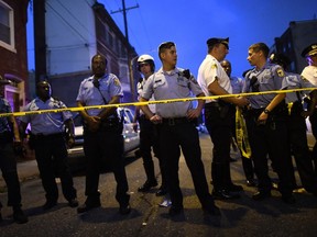 Police officers monitor activity near a residence while responding to a shooting on August 14, 2019 in Philadelphia. (Photo by Mark Makela/Getty Images)