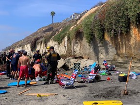 Emergency responders attend to a cliff collapse that has trapped people at a beach in Encinitas, Calif, August 2, 2019.    REUTERS/Paul Ecke