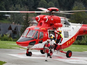 Mountain rescue team (TOPR) members board a helicopter in Zakopane, Poland August 18, 2019, to join the search operation for two cave climbers trapped in the Tatra mountains.  (Agencja Gazeta/Marek Podmokly)