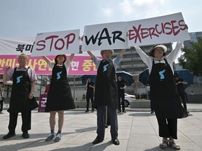 Anti-war activists hold placards reading "Stop War Exercises," during a rally against planned South Korea-US annual joint military exercises near the US embassy in Seoul on August 5, 2019.