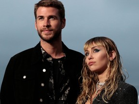 In this file photo taken on June 6, 2019, singer Miley Cyrus and husband actor Liam Hemsworth arrive for the Saint Laurent Men's Spring-Summer 2020 runway show in Malibu, Calif. (KYLE GRILLOT/AFP/Getty Images)