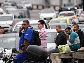 Drivers and motorcyclists wait for the traffic to be reopened after a gunman who was holding a bus with 16 hostages was shot dead by police in Rio de Janeiro, Brazil, on August 20, 2019. (Douglas Magno / AFP)