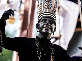 A man wearing a controversial makeup colouring blackface and called "the savage" gestures during a folk parade "Ducasse" of Ath in Ath, Belgium on August 25, 2019. - Anti-racism campaigners have called on Unesco to remove a Belgian folklore festival from its cultural heritage list unless organisers stop parading characters in blackface. The four-day carnival in the Belgian town of Ath,  features the savage, a white man in blackface, who wears a chain around his neck and a ring through his nose. According to the official festival website, the savage, chained and agitated, testifies to the taste for the exotic of the 19th century.