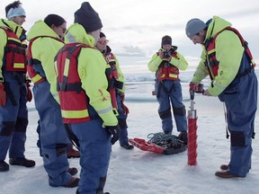 Dr. Brice Loose drills an ice core in the Canadian Arctic during of an 18-day icebreaker expedition that took place in July and August 2019, in a still image taken from a handout video obtained by REUTERS on August 14, 2019. (Northwest Passage Project/Camera: Duncan Clark via REUTERS)