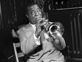 American jazzman Louis Armstrong plays trumpet in his dressing room before a show in March 1950 in New York.