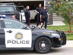 Calgary police investigate a home on Panatella Blvd. N.W., where an officer was accidentally bitten by a police dog on Friday, Aug. 16, 2019.