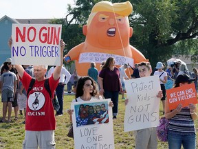 Protesters gather around a baby Trump balloon to voice their rally against gun violence and a visit from U.S. President Donald Trump following a mass shooting in Dayton, Ohio,  Aug. 7, 2019.