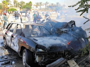 Libyans gather at the site of a car bomb attack in Libya's eastern city of Benghazi on Saturday, Aug. 10, 2019.