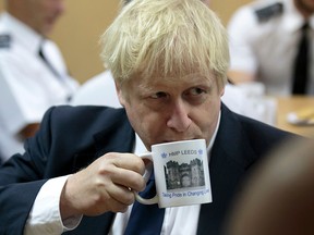 Boris Johnson drinks from a HMP Leeds prison mug as he talks with prison staff during a visit to HM Prison Leeds on August 13, 2019. (JON SUPER/AFP/Getty Images)