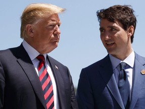 U.S. President Donald Trump talks with Canadian Prime Minister Justin Trudeau during a G-7 Summit welcome ceremony in Charlevoix, Canada on June 8, 2018.