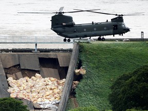 A Chinook helicopter drops sand bags at a dam after a nearby reservoir was damaged by flooding, in Whaley Bridge, Britain August 2, 2019. (REUTERS/Phil Noble)