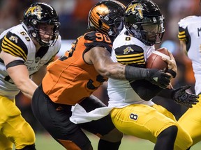 Davon Coleman sacks Tiger-Cats quarterback Jeremiah Masoli during a game last season. The Argonauts have acquired the defensive lineman from the B.C. Lions. (Darryl Dyck/The Canadian Press)