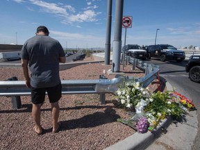 Alfredo Angcana prays beside a makeshift memorial outside the Cielo Vista Mall Wal-Mart where a shooting left 20 people dead in El Paso, Texas, on Sunday, Aug. 4, 2019.