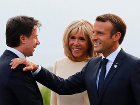 French President Emmanuel Macron (right) and his wife Brigitte Macron (centre) welcome Italian Prime Minister Giuseppe Conte at the Biarritz lighthouse, in southwestern France, ahead of a working dinner on Aug. 24, 2019, on the first day of the annual G7 Summit attended by the leaders of the world's seven richest democracies, Britain, Canada, France, Germany, Italy, Japan and the United States.