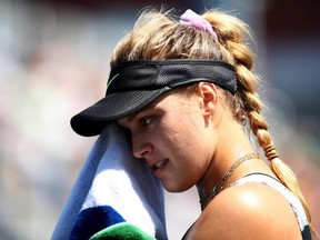 Eugenie Bouchard dries her face as she takes on Anastasija Sevastova during their Women's Singles first round match of the 2019 U.S. Open at the USTA Billie Jean King National Tennis Center in New York City on Monday, Aug. 26, 2019.
