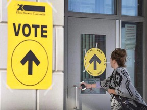 A woman enters Maple High School in Vaughan, Ont., to cast her vote in the Canadian federal election on Monday, Oct. 19, 2015. (THE CANADIAN PRESS/Peter Power)