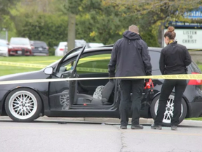 London, Ont., police officers inspect a vehicle at the scene of a shooting at the corner of Trafalgar St. and Admiral Dr. Photo taken May 11, 2019.