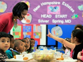 U.S. first lady Michelle Obama (L) talks to Head Start students during lunch as she visits New Hampshire Estates Elementary School,  which was awarded the USDA`s Healthier US School Challenge Silver Award in 2009 and partnered with a school in Mexico as part of the Monarch Butterfly Sister School Program, May 19, 2010 in Silver Spring, Maryland.