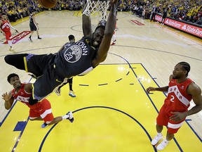 Golden State Warriors forward Draymond Green dunks the ball against Toronto Raptors centre Serge Ibaka and forward Kawhi Leonard  in game six of the 2019 NBA Finals at Oracle Arena.
