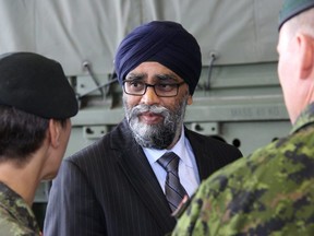 Minister of National Defence Harjit Sajjan talks with Garrison Petawawa troops during the unveiling event of the country's latest standard military pattern truck on Sept. 21, 2018.