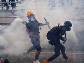 A protester throws back a tear gas canister during clashes with riot police at Kowloon Bay in Hong Kong on August 24, 2019. (LILLIAN SUWANRUMPHA/AFP/Getty Images)
