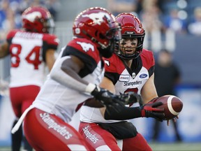 Calgary Stampeders quarterback Nick Arbuckle (9) hands off to Romar Morris (2) against the Winnipeg Blue Bombers during the first half of CFL action in Winnipeg Thursday, August 8, 2019. THE CANADIAN PRESS/John Woods