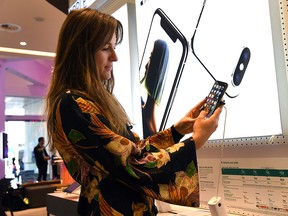 A woman inspects the latest range of Apple iPhones at a store in Melbourne on Sept. 21, 2018.