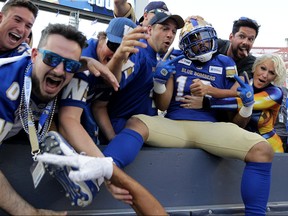 Winnipeg Blue Bombers receiver Nic Demski celebrates his touchdown catch against the B.C. Lions during CFL action with fans in the stands in Winnipeg on Thursday night.