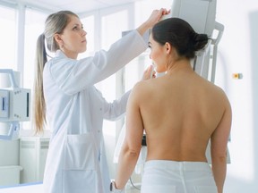 In the hospital, female patients undergo mammogram screening procedure done by a mammography technologist.