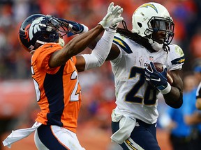 Running back Melvin Gordon of the San Diego Chargers fights off cornerback Chris Harris of the Denver Broncos at Sports Authority Field at Mile High on October 30, 2016 in Denver. (Dustin Bradford/Getty Images)