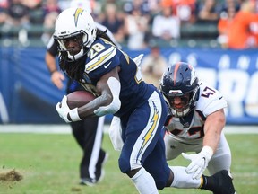 Chargers running back Melvin Gordon runs in front of Broncos linebacker Joey Jewell during third quarter NFL action at StubHub Center in Carson, Calif., on Nov. 18, 2018.