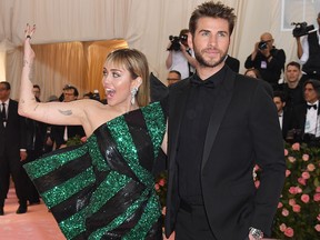 Miley Cyrus (R) and Liam Hemsworth arrive for the 2019 Met Gala at the Metropolitan Museum of Art on May 6, 2019, in New York.