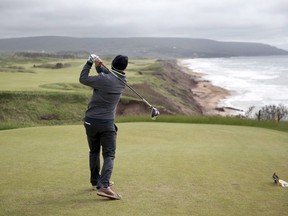 A golfer hits from the tee on the 528 yard, par 5, 18th hole at Cabot Cliffs, the seaside links golf course in Inverness, N.S. on June 1, 2016.